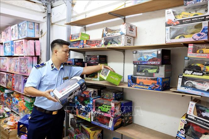 Lực lượng chức năng kiểm tra đồ chơi trẻ em tại cửa hàng số 3B Đồng Xuân. Ảnh: Trần Việt - TTXVN