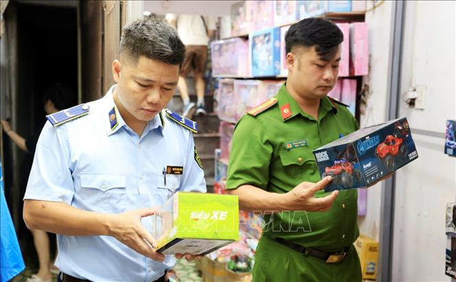 Lực lượng chức năng kiểm tra đồ chơi trẻ em tại cửa hàng số 3B Đồng Xuân. Ảnh: Trần Việt - TTXVN