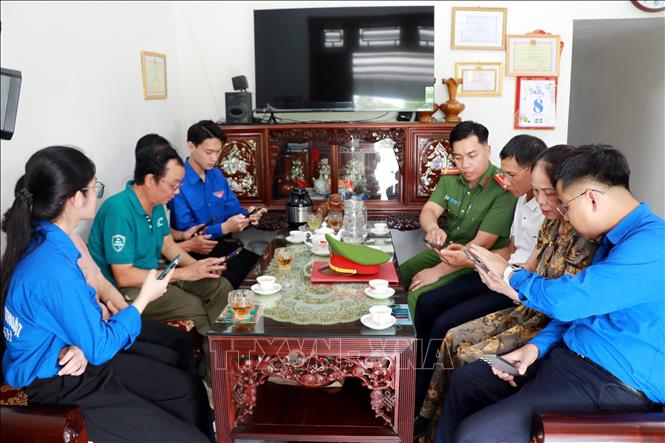 Công an, Đoàn thanh niên phường Thiên Trường (Ninh Bình) tuyên truyền, hướng dẫn người dân truy cập nhóm Zalo an ninh trật tự. Ảnh: Nguyễn Lành - TTXVN 