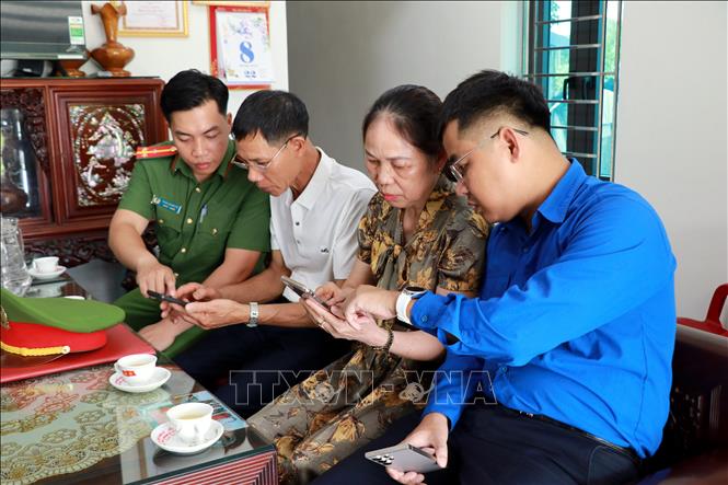Công an, Đoàn thanh niên phường Thiên Trường (Ninh Bình) tuyên truyền, hướng dẫn người dân truy cập nhóm Zalo an ninh trật tự. Ảnh: Nguyễn Lành - TTXVN 