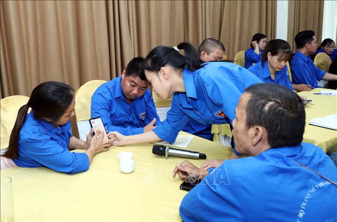 Hướng dẫn thanh niên khuyết tật truy cập, sử dụng các tiện ích số. Ảnh: Nguyễn Lành - TTXVN 