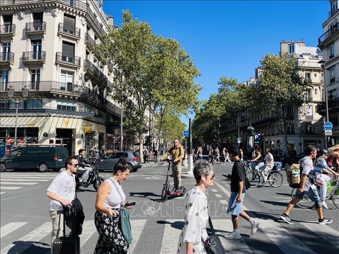 Nhịp sống sôi động trên đường phố Paris với dòng người đi bộ, xe đạp và các phương tiện cá nhân giữa những dãy nhà mang đậm dấu ấn kiến trúc đô thị Pháp. Ảnh: Trần Đức Hùng - PV TTXVN tại Pháp