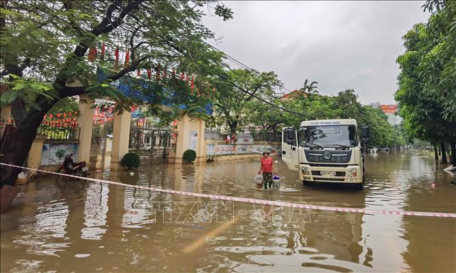 Nước ngập bên ngoài và trong trường Tiểu học Tây Mỗ (phường Tây Mỗ). Ảnh: Thanh Tùng - TTXVN 