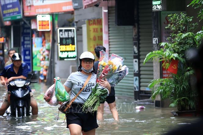 Phố Triều Khúc, phường Thanh Liệt ngập sâu ảnh hưởng đến việc đi lại của người dân. Ảnh: Tuấn Anh - TTXVN