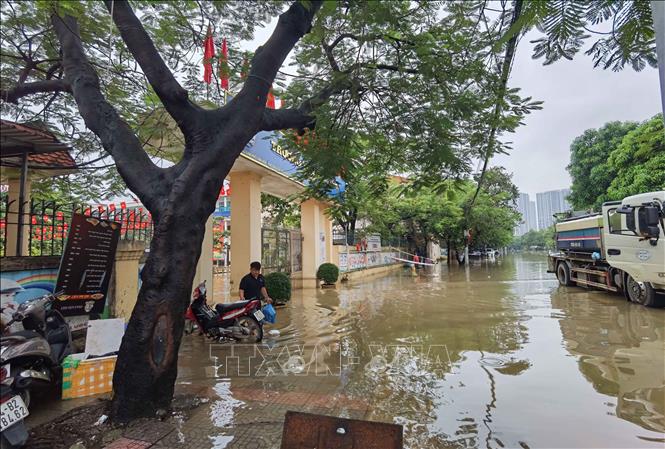 Nước ngập bên ngoài và trong trường Tiểu học Tây Mỗ (phường Tây Mỗ). Ảnh: Thanh Tùng - TTXVN 