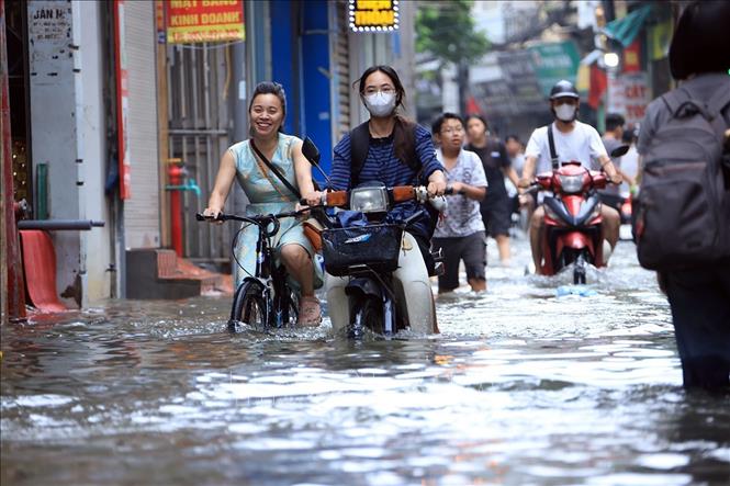 Phố Triều Khúc, phường Thanh Liệt ngập sâu ảnh hưởng đến việc đi lại của người dân. Ảnh: Tuấn Anh - TTXVN