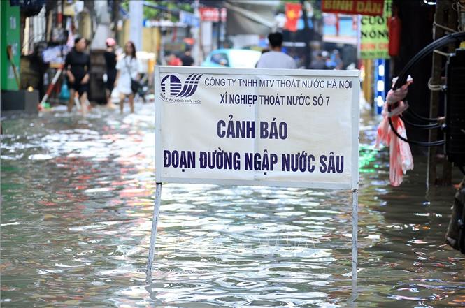 Một biển cảnh báo của Công ty TNHH Một thành viên Thoát nước Hà Nội khi có điểm bị ngập sâutrên phố Triều Khúc, phường Thanh Liệt.. Ảnh: Tuấn Anh - TTXVN