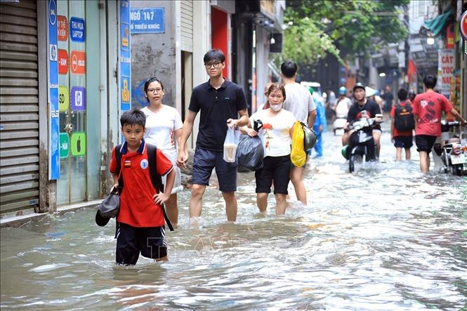 Phố Triều Khúc, phường Thanh Liệt ngập sâu ảnh hưởng đến việc đi lại của người dân. Ảnh: Tuấn Anh - TTXVN
