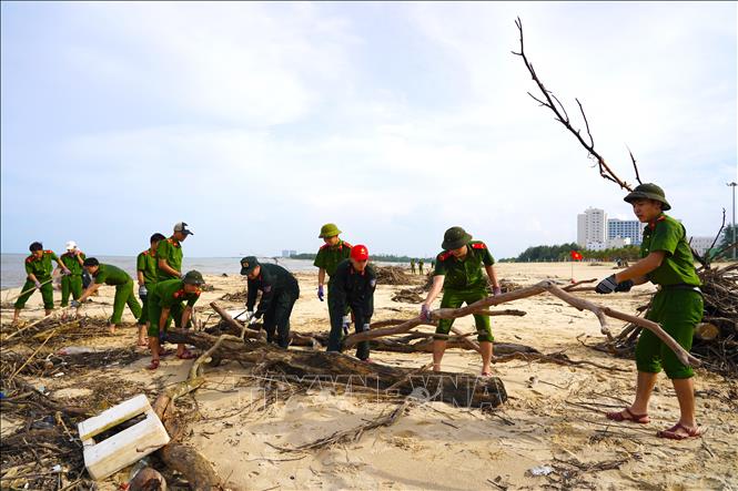 Lực lượng chức năng khẩn trương dọn rác, làm sạch bãi biển Nhật Lệ sau mưa lũ. Ảnh: Thanh Thuỷ-TTXVN                               