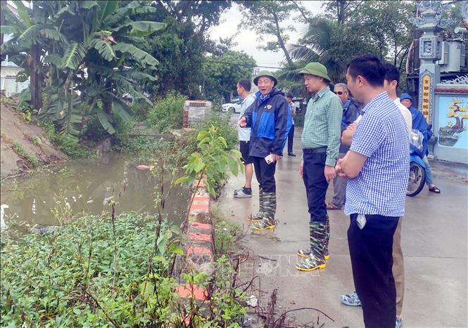 Lãnh đạo xã Nghĩa Trụ kiểm tra công tác tiêu thoát nước, khắc phục mưa ngập trên địa bàn. Ảnh: Mạnh Khánh - TTXVN 