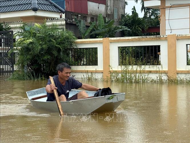 Thuyền, bè là phương tiện di chuyển trong ngày lũ của người dân vùng lũ Thạch Định. Ảnh: Hoa Mai - TTXVN