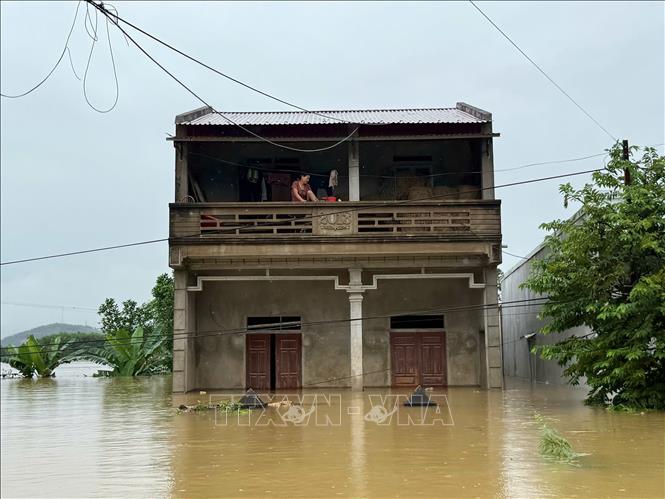 Một căn nhà chơi vơi trong dòng nước lũ ở xã Kim Tân, người dân phải sơ tán tại chỗ chờ cứu hộ. Ảnh: Hoa Mai - TTXVN 