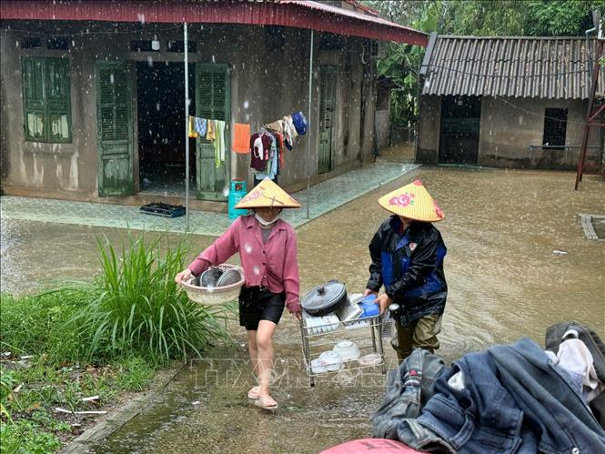 Khẩn trương sơ tán vật dụng lên cao để tránh lũ. Ảnh: Hoa Mai - TTXVN