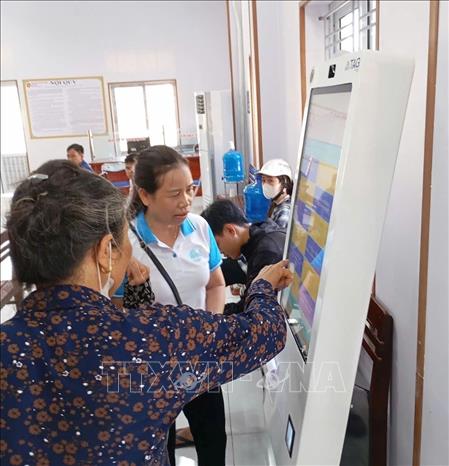 Cán bộ Hội Phụ nữ xã Chí Minh, thành phố Hải Phòng hỗ trợ hội viên tại Trung tâm Phục vụ hành chính công. Ảnh: Mạnh Minh - TTXVN