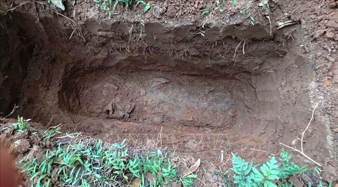Hài cốt được tìm thấy ở độ sâu khoảng 1,2m, trong tình trạng phân hủy nhiều, nằm nguyên trong tăng. Ảnh: TTXVN phát