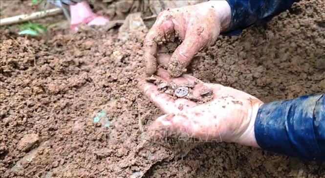 Các di vật kèm theo gồm 12 cúc áo quần bộ đội, 11 đinh đóng quan tài và một cuộn dây điện thông tin dài khoảng 15m. Ảnh: TTXVN phát