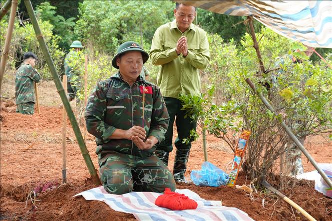 Thắp hương trước khi đưa hài cốt liệt sĩ về khu vực tập trung. Ảnh: Hồng Ninh - TTXVN