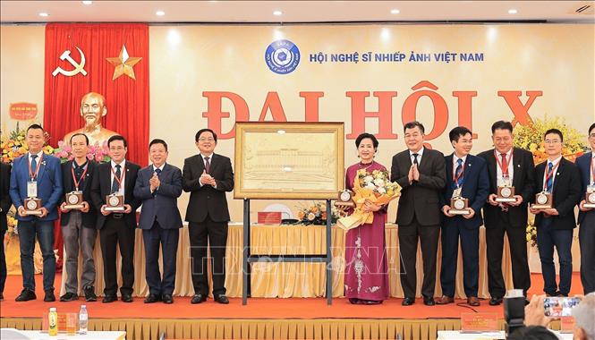 Ủy viên Trung ương Đảng, Phó Thủ tướng Chính phủ Hồ Quốc Dũng, NS Đỗ Hồng Quân, Phó Chủ tịch không chuyên trách Uỷ ban Trung ương MTTQ Việt Nam, Bí thư Đảng ủy, Chủ tịch Liên hiệp các Hội Văn học Nghệ thuật Việt Nam và đồng chí Nguyễn Đức Phong, Uỷ viên Ban Thường vụ Đảng ủy MTTQ Việt Nam, các đoàn thể Trung ương, Phó Chủ tịch Uỷ ban Trung ương MTTQ Việt Nam tặng quà lưu niệm cho Ban Chấp hành Hội Nghệ sĩ Nhiếp ảnh Việt Nam khoá X nhiệm kỳ 2026 - 2031. Ảnh: Lê Đông - TTXVN
