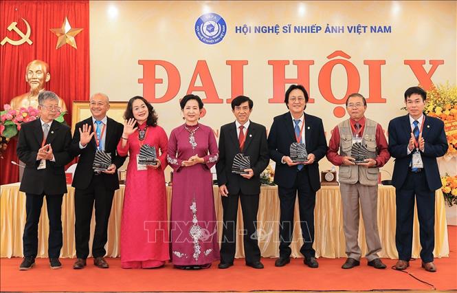 Đồng chí Trần Thị Thu Đông, Chủ tịch Hội Nghệ sĩ Nhiếp ảnh Việt Nam khoá X tặng hoa cảm ơn các đồng chí Ủy viên BCH khoá IX không tham gia khoá X. Ảnh: Lê Đông - TTXVN