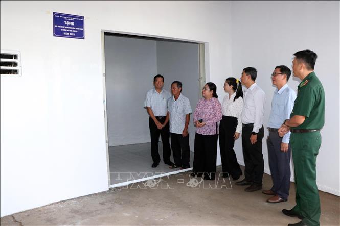 Các đại biểu tham quan căn nhà mới và thăm hỏi, động viên gia đình. Ảnh: Trung Kiên - TTXVN