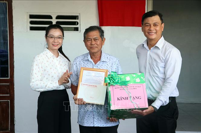 Lãnh đạo xã Gia Hòa trao Quyết định tặng nhà và quà mừng của địa phương cho đại diện gia đình bà Võ Thị Liến. Ảnh: Trung Kiên - TTXVN