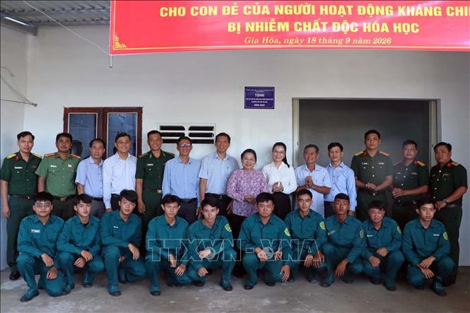 Các đại biểu cùng lực lượng vũ trang thăm và chúc mừng hộ gia đình chính sách được nhận nhà mới tại xã Gia Hòa. Ảnh: Trung Kiên - TTXVN