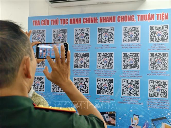 Người dân sử dụng mã QR để tra cứu thông tin thủ tục hành chính tại điểm hỗ trợ chuyển đổi số cộng đồng. Ảnh: Trung Nguyên - TTXVN