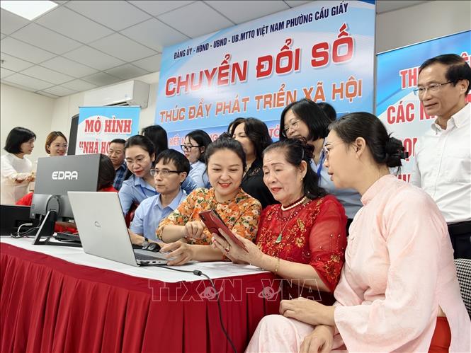 Người dân được hướng dẫn sử dụng các tiện ích số tại mô hình “Nhà họp số” phường Cầu Giấy. Ảnh: Trung Nguyên - TTXVN