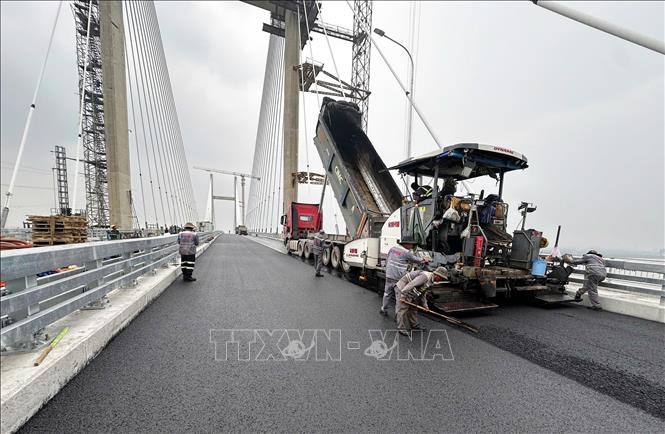Máy móc, nhân lực thực hiện thảm nhựa tại Dự án mở rộng đoạn cao tốc Thành phố Hồ Chí Minh - Long Thành. Ảnh: Công Phong - TTXVN