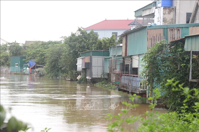 Phần cơi nới làm công trình phụ trợ của nhiều hộ dân sinh sống ven sông Bùng có nguy cơ bị ngập khi chỉ còn cách mép nước từ 30 đến 50cm. Ảnh: Xuân Tiến - TTXVN 