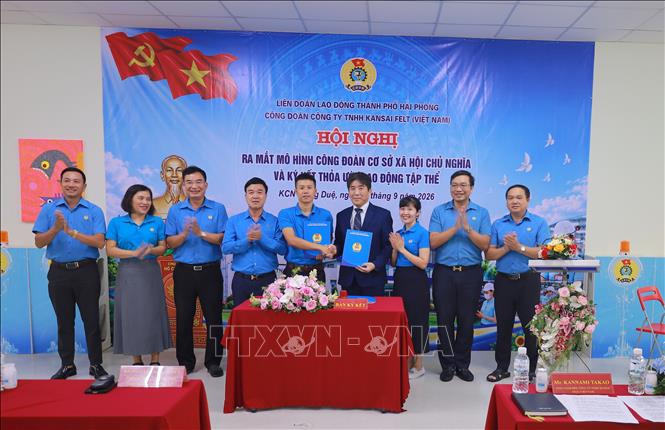 Lãnh đạo Công ty và Chủ tịch công đoàn công ty ký thỏa ước lao động tập thể. Ảnh: Minh Thu - TTXVN