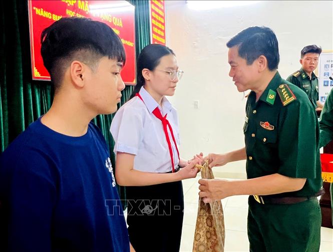 Đại tá Hoàng Văn Mẫn, Bí thư Đảng ủy, Chính ủy Bộ đội Biên phòng thành phố Đà Nẵng (bên phải) trao quà cho học sinh có hoàn cảnh khó khăn trên địa bàn. Ảnh: Quốc Dũng - TTXVN