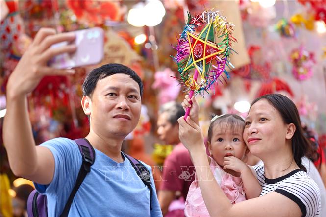 Lưu lại khoảng khắc đẹp trong không khí rực rỡ sắc màu của chợ Trung thu truyền thống. Ảnh: Thanh Tùng -  TTXVN