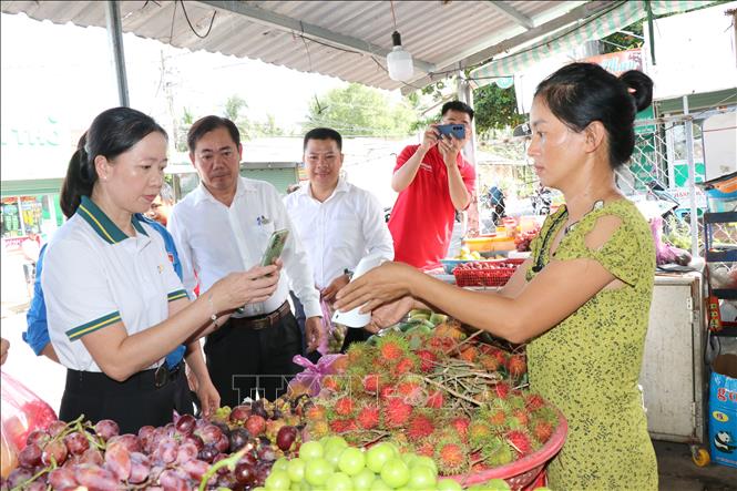 Lãnh đạo địa phương và các đơn vị đồng hành tuyên truyền, hướng dẫn tiểu thương thanh toán không dùng tiền mặt. Ảnh: Thanh Hòa - TTXVN