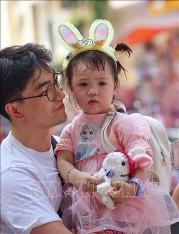 Lần đầu tới chợ Trung thu truyền thống nên bé vẫn còn nhiều lạ lẫm. Ảnh: Thanh Tùng -  TTXVN