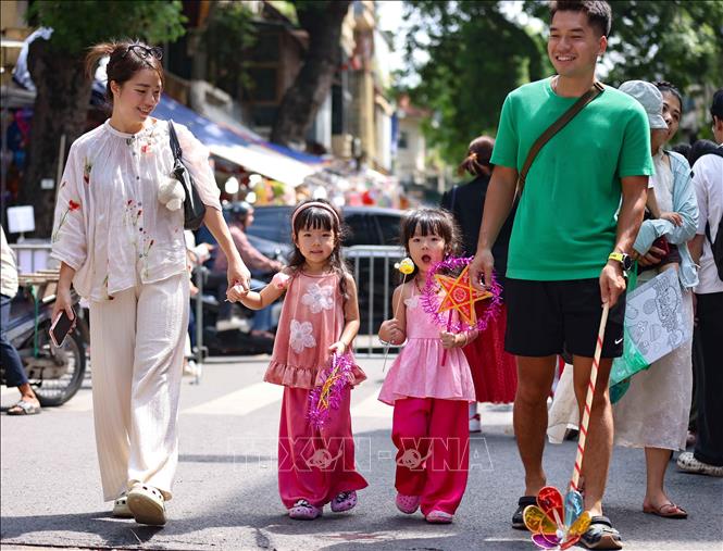 Một gia đình vui tươi, rạng rỡ đi chợ Trung thu truyền thống. Ảnh: Thanh Tùng -  TTXVN
