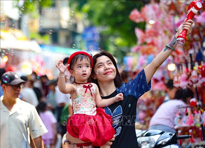 Trẻ vui tươi khi được hòa mình vào không khí rực rỡ sắc màu Trung thu trên phố Hàng Mã. Ảnh: Thanh Tùng -  TTXVN 
