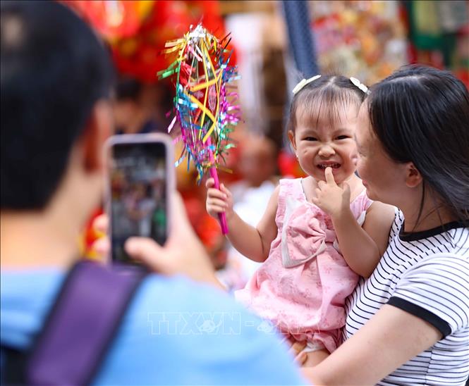 Lưu lại khoảng khắc đẹp trong không khí rực rỡ sắc màu của chợ Trung thu truyền thống. Ảnh: Thanh Tùng -  TTXVN
