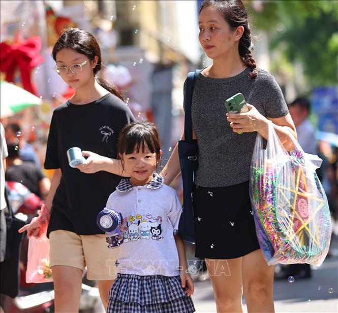 Trẻ vui tươi khi được hòa mình vào không khí rực rỡ sắc màu trung thu trên phố Hàng Mã. Ảnh: Thanh Tùng -  TTXVN 