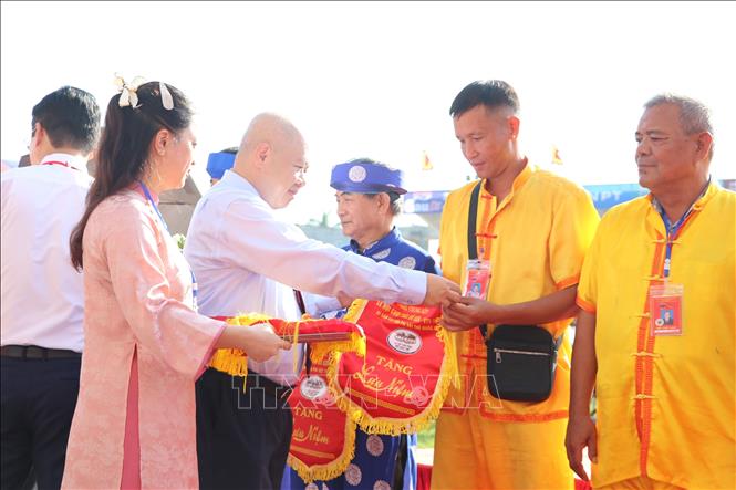 Chủ tịch UBND thành phố Hải Phòng Đỗ Thành Trung tặng hoa và cờ lưu niệm cho 15 ông chủ trâu có trâu tham dự vòng chung kết. Ảnh: Mạnh Minh - TTXVN