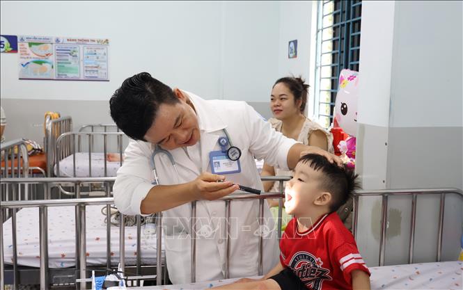 Bác sĩ Bệnh viện Nhi đồng 1 Thành phố Hồ Chí Minh đang kiểm tra tình trạng bệnh cho bệnh nhi. Ảnh: Đinh Hằng - TTXVN