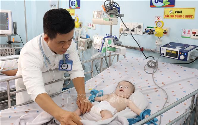Bác sĩ Dư Tuấn Quy, Trưởng Khoa Nhiễm - Thần kinh, Bệnh viện Nhi đồng 1 Thành phố Hồ Chí Minh kiểm tra tình trạng bệnh cho bệnh nhi nặng phải nằm phòng cấp cứu. Ảnh: Đinh Hằng - TTXVN
