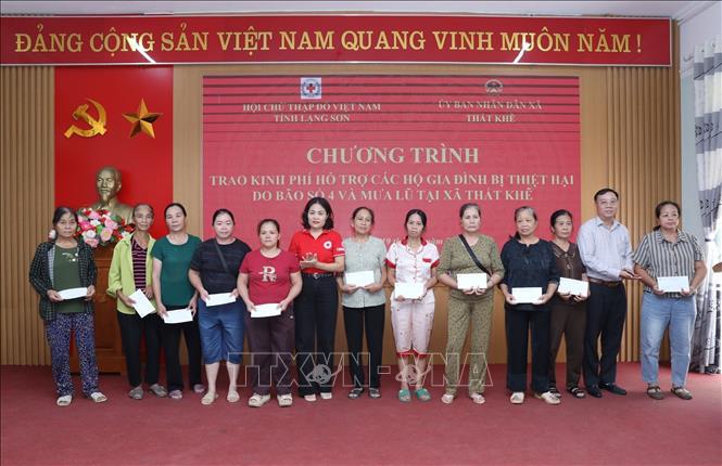 Phó Chủ tịch Hội Chữ thập đỏ tỉnh Lạng Sơn Trần Thị Phương Trinh và Chủ tịch Liên minh HTX tỉnh Lạng Sơn Liễu Xuân Du trao kinh phí hỗ trợ các hộ gia đình bị ảnh hưởng bởi bão số 4 và mưa lũ trên địa bàn xã Thất Khê. Ảnh: Anh Tuấn – TTXVN