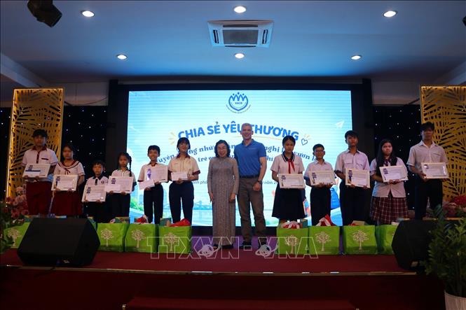 Bà Mai Thị Ngọc Mai, Chủ tịch Hội Bảo vệ Quyền trẻ em Thành phố Hồ Chí Minh và ông Damien Roberts, Giám đốc điều hành tổ chức Saigon Children's Charity CIO trao học bổng cho các em học sinh có hoàn cảnh khó khăn. Ảnh: Thanh Vũ – TTXVN
