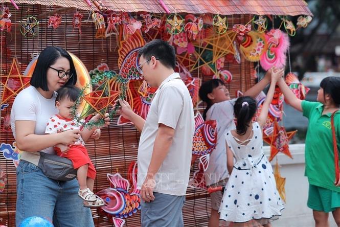Young families choose and discover traditional Mid-Autumn Festival toys. VNA Photo: Phạm Tuấn Anh