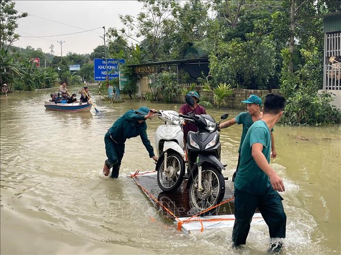 Cán bộ Công ty Trách tnhiệm hữu hạn Một thành viên Sông Chu cùng lực lượng chức năng hỗ trợ người dân vùng ngập lụt. Ảnh: Khiếu Tư - TTXVN