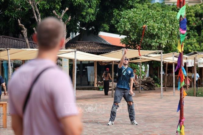 International tourists experience con (cloth ball) throwing game at Ho Van. VNA Photo: Phạm Tuấn Anh
