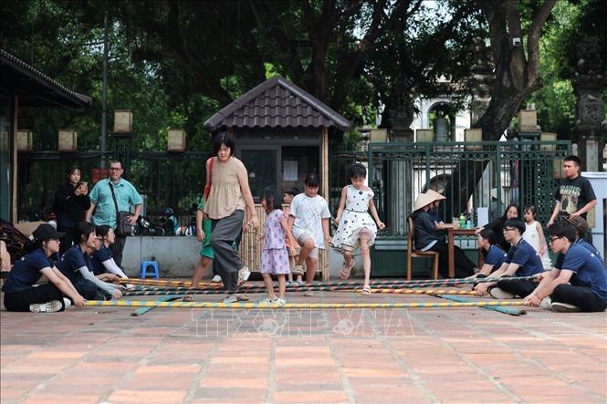Children experience mua sap (bamboo dance) at Ho Van. VNA Photo: Phạm Tuấn Anh