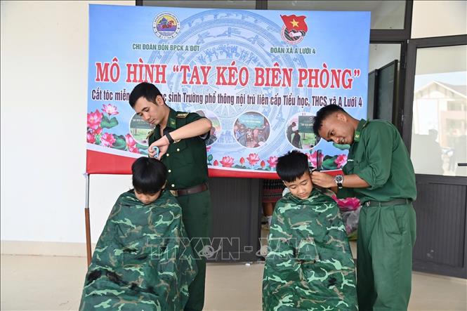 Mô hình “Tay kéo Biên phòng” cắt tóc cho trẻ em do Đồn Biên phòng Cửa khẩu A Đớt tổ chức. Ảnh: Mai Trang - TTXVN 