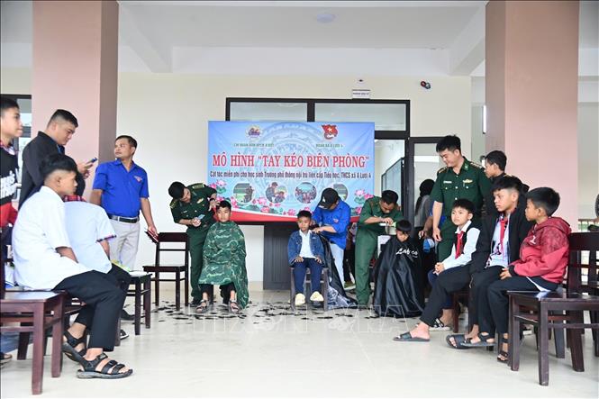 Mô hình “Tay kéo Biên phòng” cắt tóc cho trẻ em do Đồn Biên phòng Cửa khẩu A Đớt tổ chức. Ảnh: Mai Trang - TTXVN 